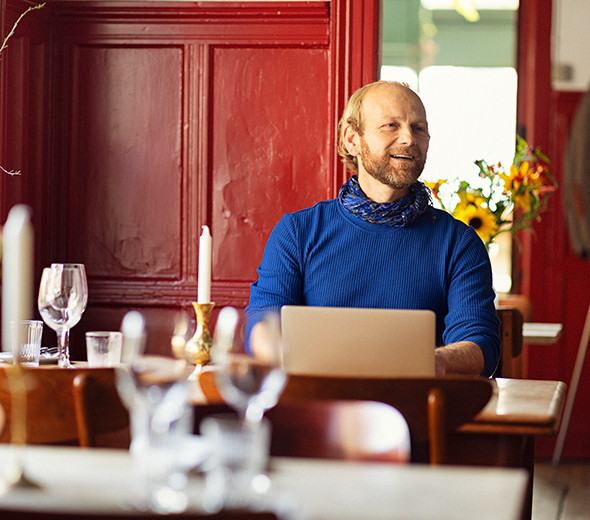 Mand sidder ved sin computer på en restaurant